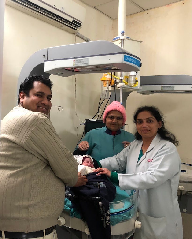 Newborn with parents and Dr. Pooja Chitlangia